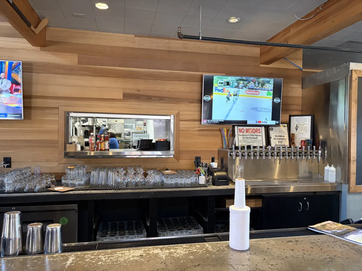 Back bar at Sunriver Brewing with cedar wall, taps and pass-through to the kitchen