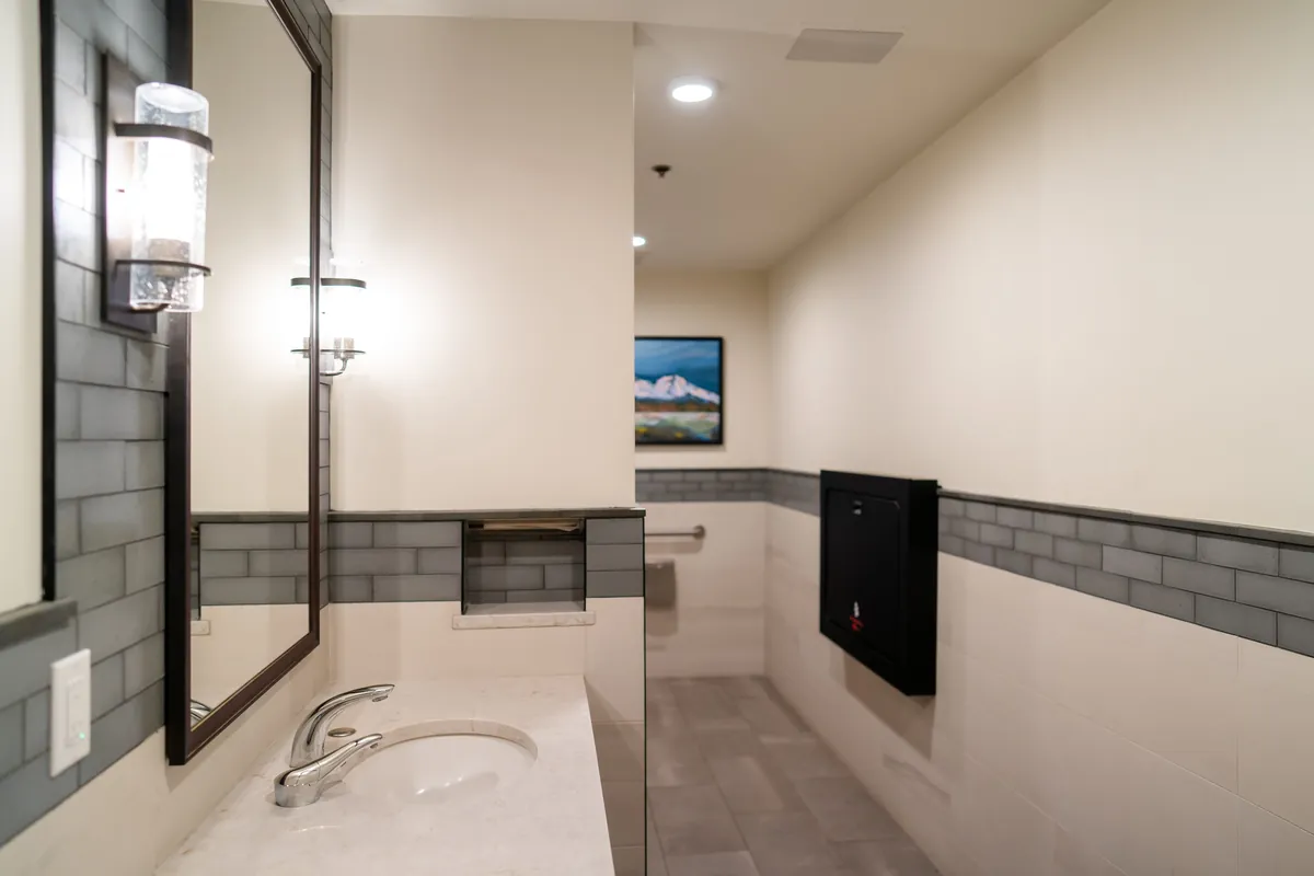Lodge restroom with new tile wainscot, vanity and partitions