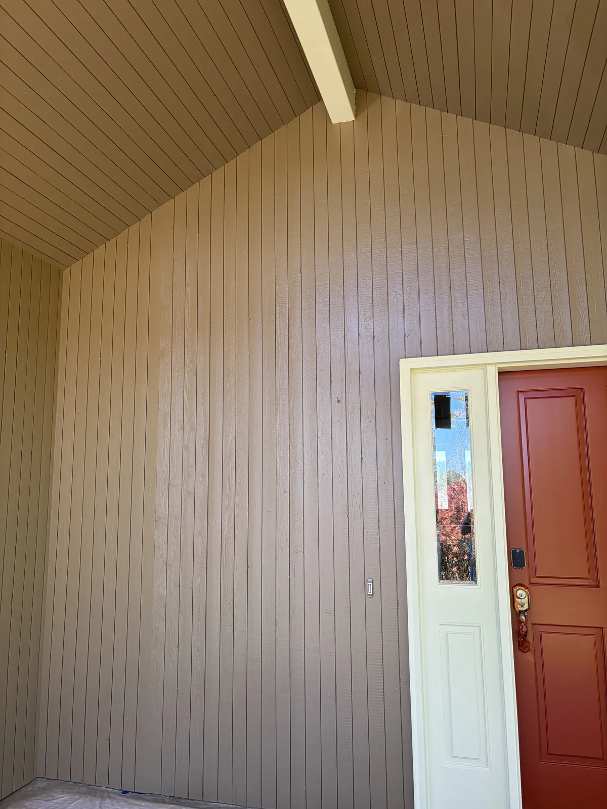 Front entry wall after the siding was replaced, next to the red front door