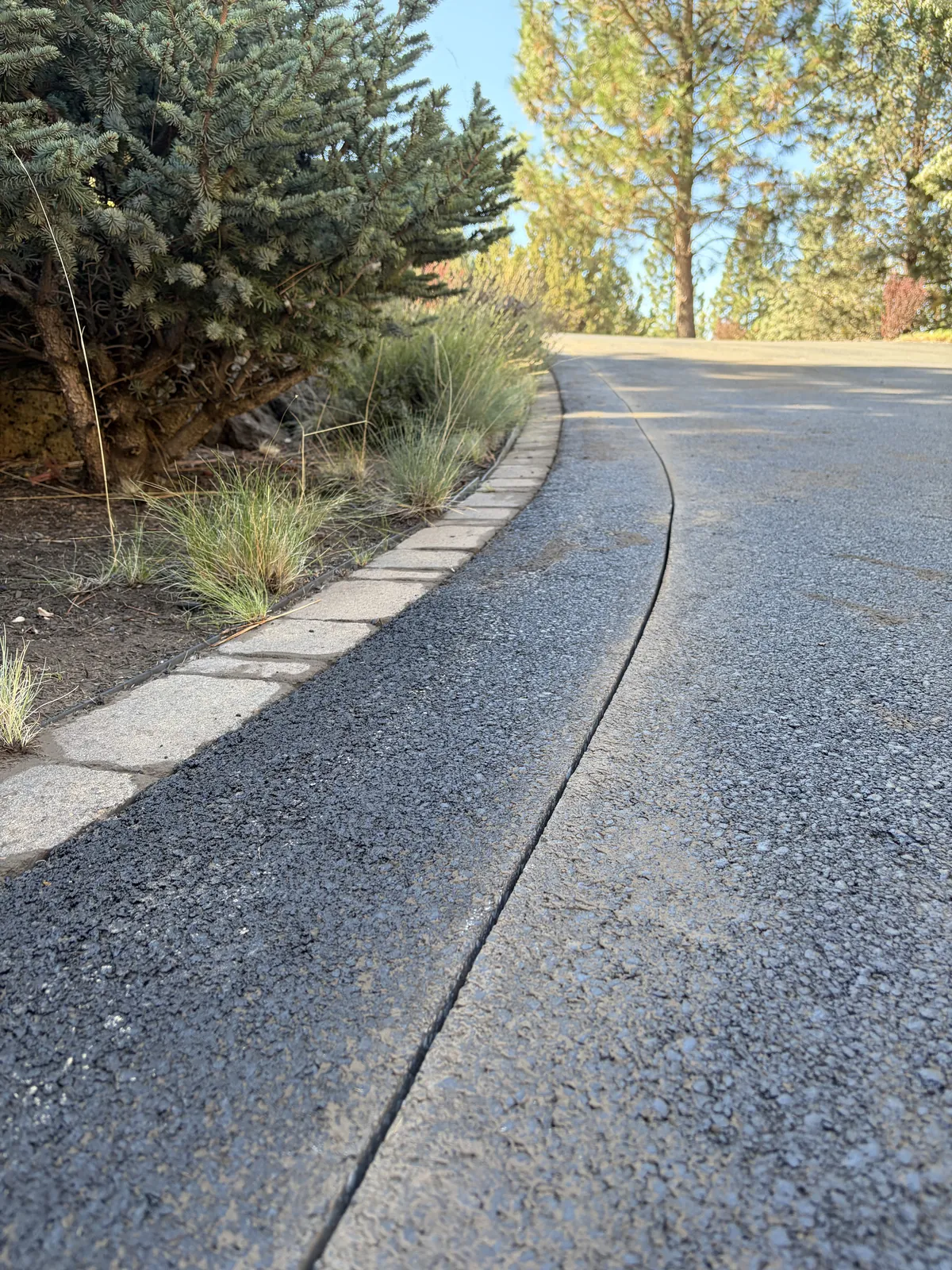 Resurfaced driveway with paver border at a Central Oregon property