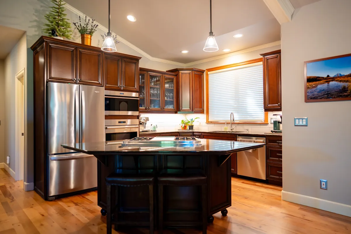 Cherry kitchen with island, stainless appliances and hardwood floor