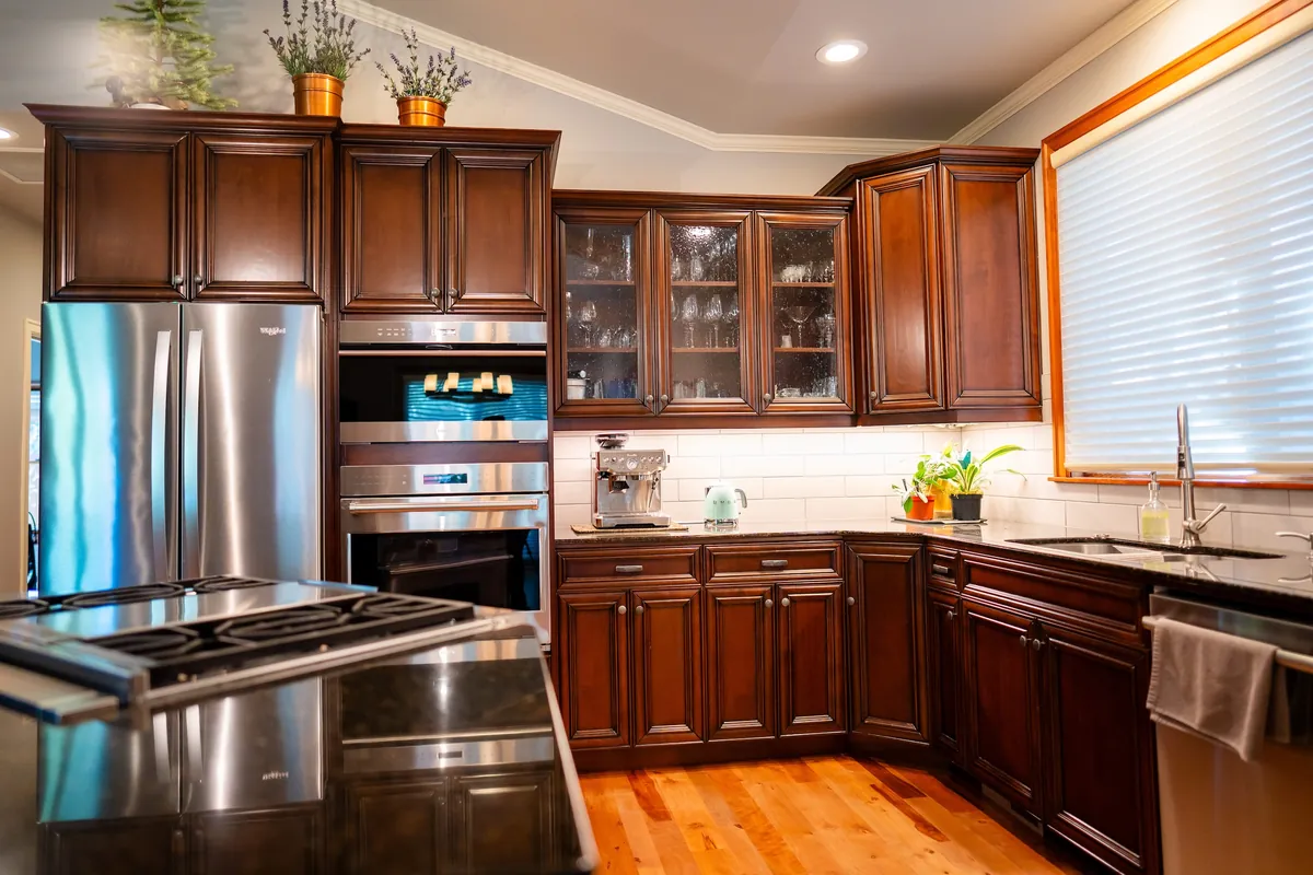 Cherry kitchen cabinetry with range and stainless appliances