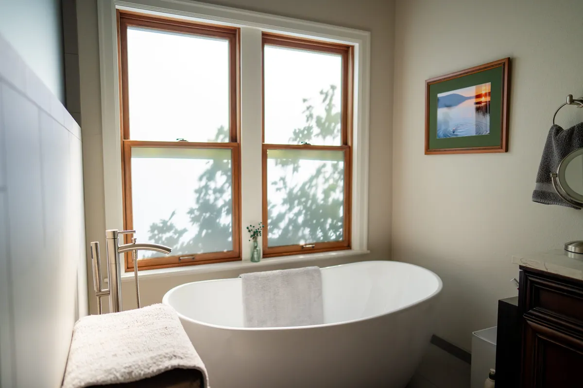 Freestanding tub under a wood-trimmed window