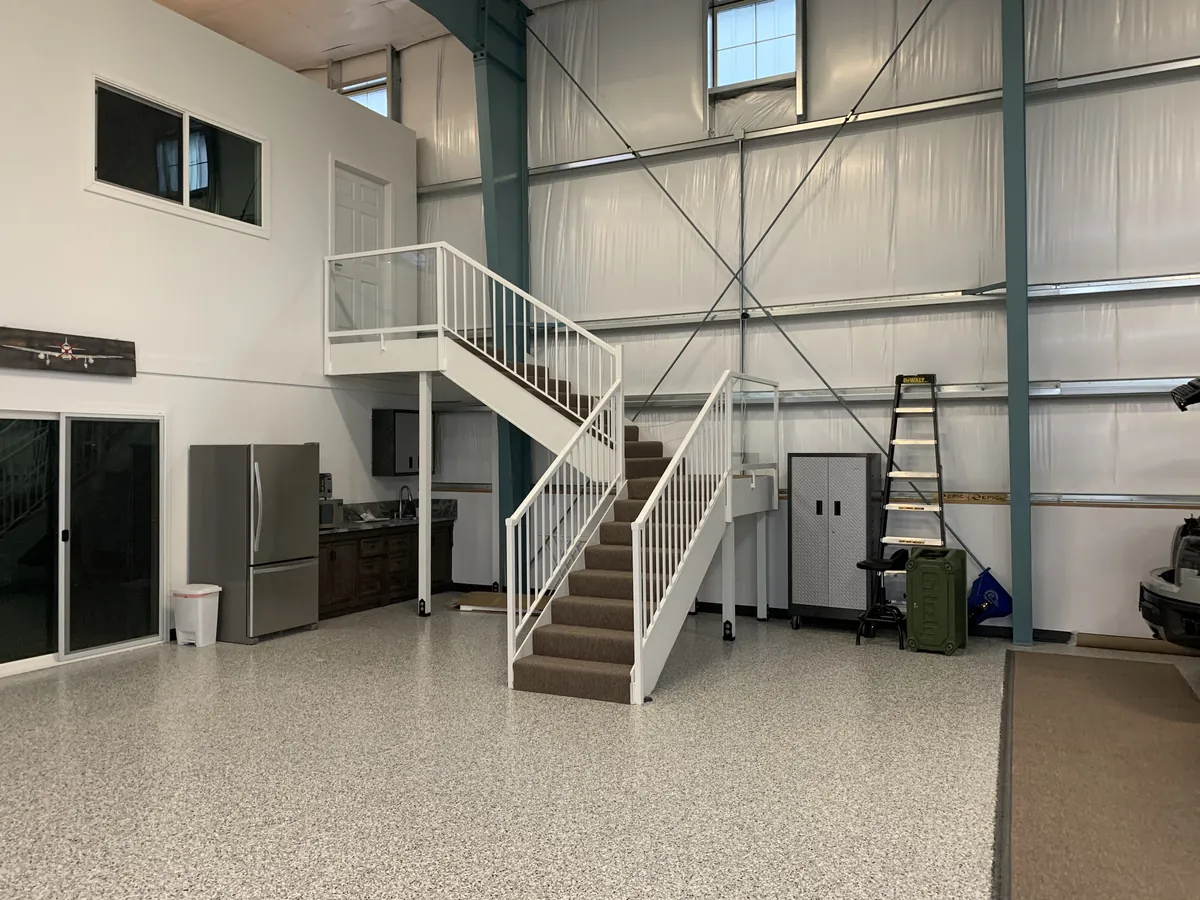 Metal building interior finished with a loft, stairs and epoxy floor